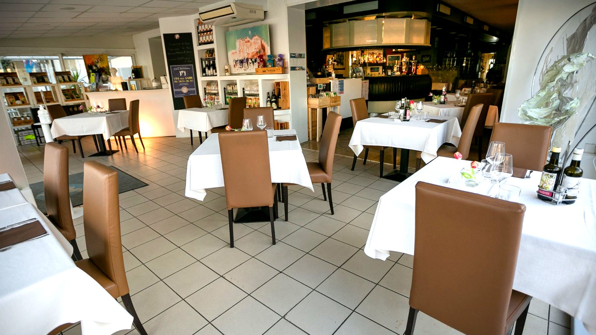 Sala del ristorante Ristò Italia apparecchiata con piatti di pesce del Delta del Po